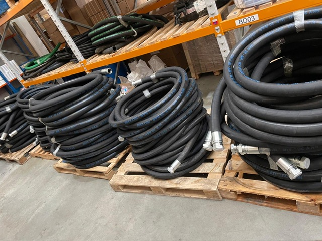 water treatment hoses Coiled black water treatment hoses on wooden pallets in a warehouse.